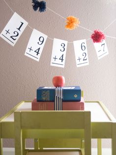 books are stacked on top of each other in front of a string with numbers hanging from it