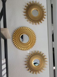 three mirrors are hanging on the wall next to each other