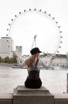 a woman sitting in front of the london eye