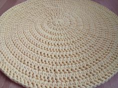 a crocheted round rug is on the floor