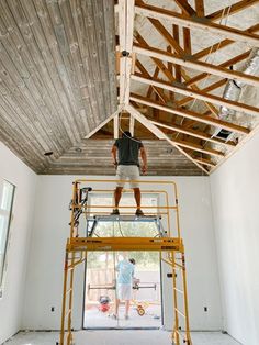 a man is standing on a scaffold in the middle of an unfinished room