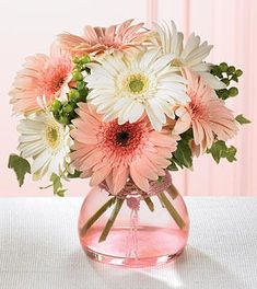 two pictures of flowers in a vase on a table