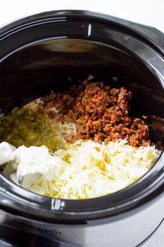 the food in the slow cooker is mixed with cheese and other ingredients to make an entree