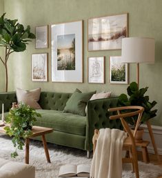 a living room with green walls and pictures on the wall above the couch, along with potted plants