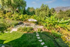 an aerial view of a garden with steps leading up to the patio and trees in the background