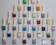 many paint brushes are arranged in rows on the wall