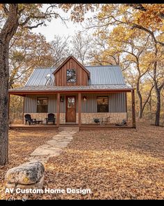 a small house in the woods surrounded by trees and leaves, with a stone pathway leading up to it