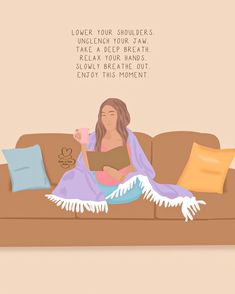 a woman sitting on top of a couch under a blanket holding a book and cup