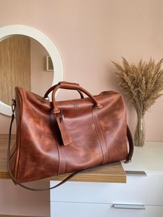 ✦This leather travel bag has one exterior pocket . The inside of this leather briefcase is very spacious and can accommodate, besides the laptop, a photo camera and a change of clothes. This can be used also as a leather travel bag or a weekender bag. It is comfortable for everyday use as it weighs under 2 kg (4 lbs).  ✦This leather bag is entirely handmade, form top quality leather, entirely handstitched with 1 mm waxed nylon thread and will keep its shape and will age gracefully. ✦The strap is made from two pieces and is adjustable up to 155 cm (61 inch). ✦The inside have 3 pockets with linings and 1 ziper pocket for you laptop. ✦Sizes :50*26*21 cm ✦Leather I use distressed top grain cowhide leather, of the best quality. It's solid, but very soft. The distressed nature allows it to age b Classic Leather Travel Bag For Trips, Classic Weekender Bag With Leather Backing For Trips, Classic Leather Weekender Bag For Trips, Classic Leather Briefcase For Trips, Leather Briefcase With Leather Lining For Trips, Leather Briefcase For Overnight Trips, Luxury Weekender Bag For Trip, Luxury Weekender Bag With Leather Backing For Trips, Luxury Brown Briefcase For Overnight Trips