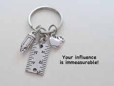 a measuring tape and apple keychain with the words your influence is immeasurable