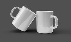 two white coffee mugs sitting next to each other on a gray background, one is half full and the other half empty