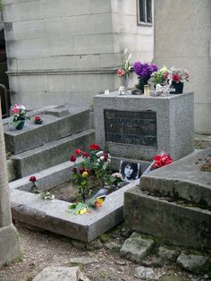 several cement headstones with flowers on them