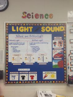 a science poster on the wall with information about light and artificial lights in front of it