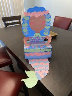 an open box sitting on top of a table with paper cut outs in the shape of a woman's face