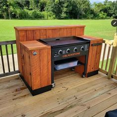 an outdoor bbq grill sitting on top of a wooden deck