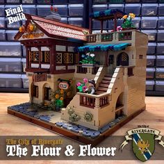 a lego model of a house with flowers on the front and stairs leading up to it