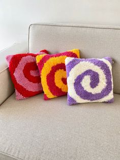 three decorative pillows are sitting on a couch