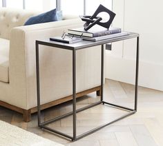 a white couch sitting next to a table on top of a hard wood floored floor