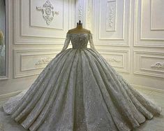 a wedding dress on display in a white room