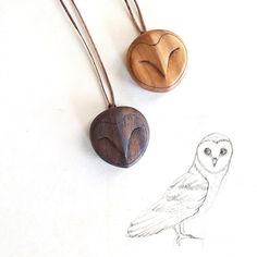 an owl is standing next to two wooden pendants