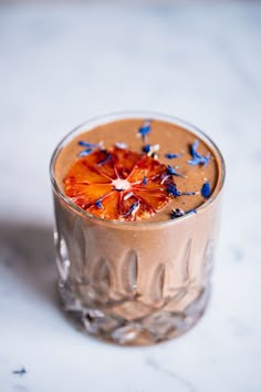 a chocolate drink with blue sprinkles in a glass on a marble surface