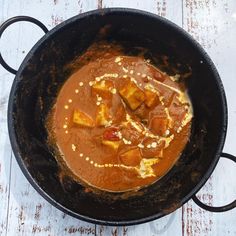 a pan filled with food sitting on top of a wooden table