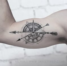 a man's arm with an arrow and compass tattoo on it