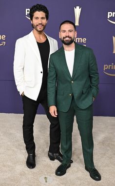 two men standing next to each other in front of a purple wall with the words prime time on it