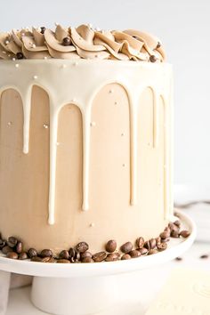 a cake with white frosting and coffee beans on top is sitting on a plate