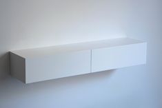 a white shelf mounted to the side of a wall