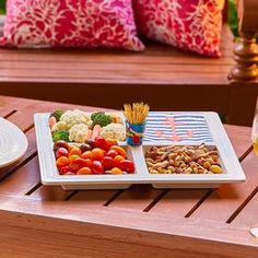 a tray of food sitting on top of a wooden table next to a glass of wine