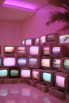 a room filled with lots of tvs sitting on top of each other in front of a palm tree