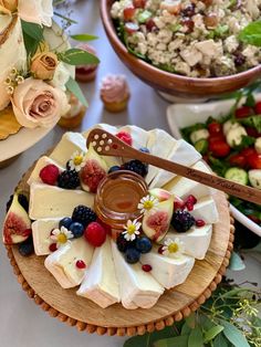 an assortment of desserts are displayed on wooden platters with flowers and greenery