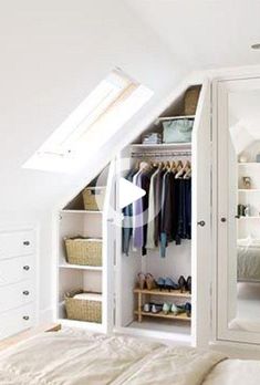 an attic bedroom with white walls and closets