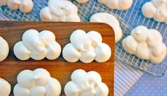 there are many small white donuts on the cooling rack next to some other ones