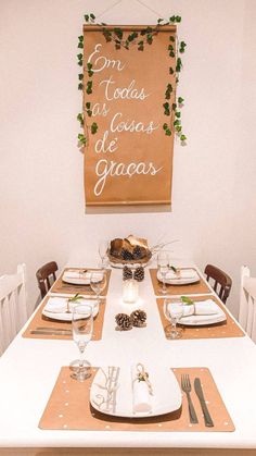 a table set with place settings for two people and a sign hanging on the wall