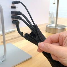 a hand holding an open zipper on top of a desk