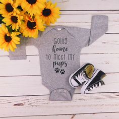 a baby bodysuit with the words going home to meet my pups on it