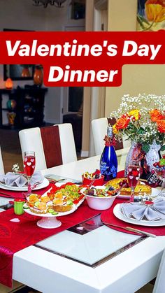 a valentine's day dinner table set with plates and glasses on it, surrounded by flowers