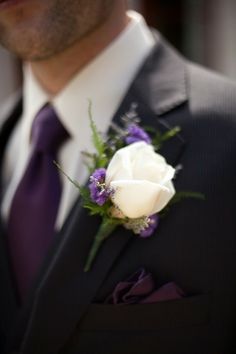 a man in a suit and tie with a boutonniere on his lapel