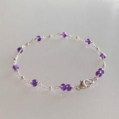 Genuine African purple amethyst bracelet, wire-wrapped in sterling silver. This minimal and feminine bracelet features genuine, premium-quality, finely faceted, perfectly round, vibrant purple amethyst gemstones (3.5mm) evenly spaced along sterling silver satellite chain. The tiny dots on the chain adds extra sparkle to this bracelet and it is finished with sterling silver clasp. A minimalist-style, February birthstone bracelet suitable for any occasion ! Details: *  length: please choose at check out (see notes below on measurement) genuine dark purple amethyst (3.5 mm) sterling silver satellite chain, clasp and components *  Choosing your length at checkout:  I recommend 1/2 inch larger than your actual wrist/ankle size. Bracelet/anklet is measured from end-to-end including clasp. Thanks Feminine Bracelet, Bracelet Inspo, Stack Bracelet, Purple Gems, Gems Bracelet, Birthstone Bracelet, Vibrant Purple, Birthstone Bracelets, Minimalist Bracelet