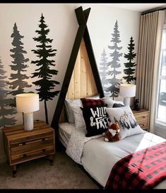 a bedroom decorated in black and white with trees on the wall