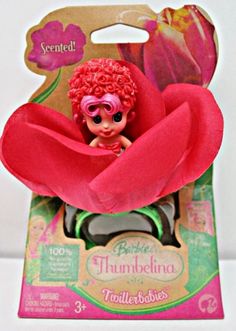 a pink doll with red hair and sunglasses in a flower shaped box on a white background