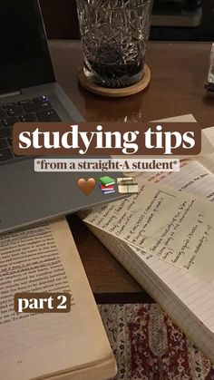 an open book sitting on top of a wooden table next to a laptop and notebook