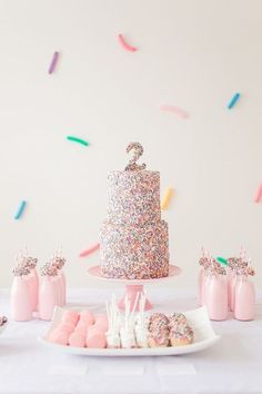 a table topped with a cake covered in sprinkles