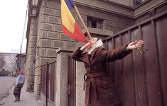 a woman holding a flag in front of a building