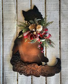 a metal horse head with a red and black bow on it's back hanging from a wooden wall