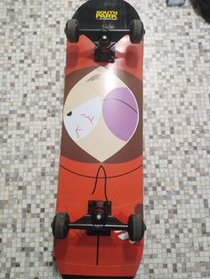 a skateboard with an image of a woman on the front and back wheels sitting on a tiled floor