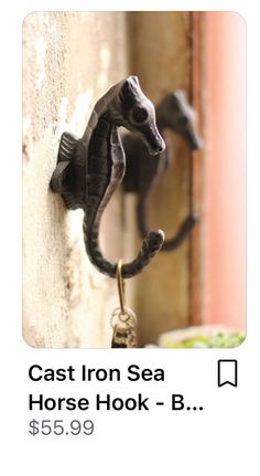 an iron sea horse hook on the side of a building with text reading cast iron sea horse hook b $ 65 99