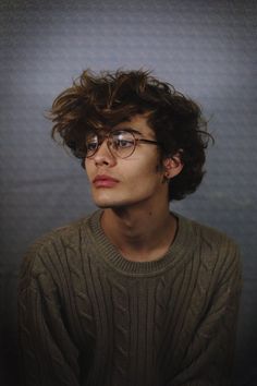 a young man with glasses looking at the camera